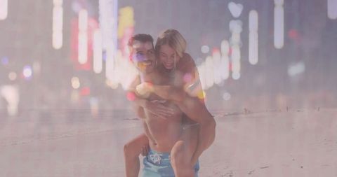 Happy couple enjoying a beach carry at dusk