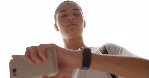 Young man interacting with smartwatch below eye level view