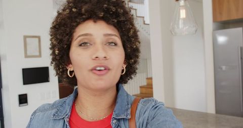 Woman taking selfie in contemporary kitchen with marble island