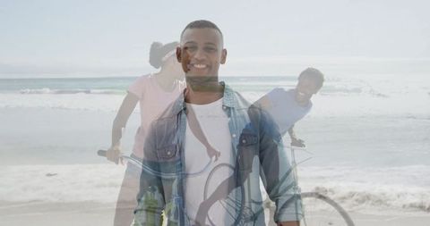 Man Smiling on Scenic Beach with Friends Cycling in Background