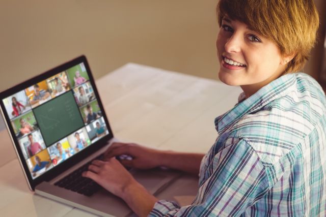 Teenager sitting at desk, actively engaging in virtual class on laptop, perfect for illustrating online learning, remote education, e-learning, or digital classroom concepts. Useful for educational websites, e-learning platforms, and online class promotional materials.