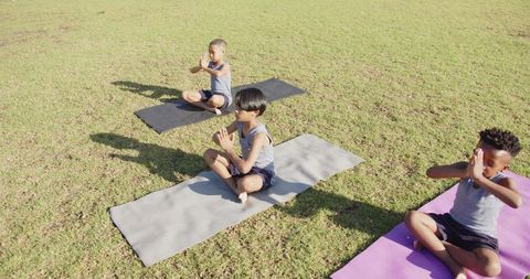 Children Meditating Outdoors on Yoga Mats in Group School Activity