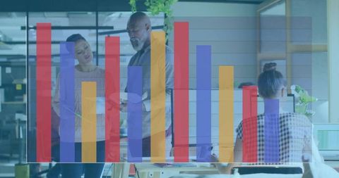 Collaborating around tablet with colorful bar chart overlay in modern open-plan workspace
