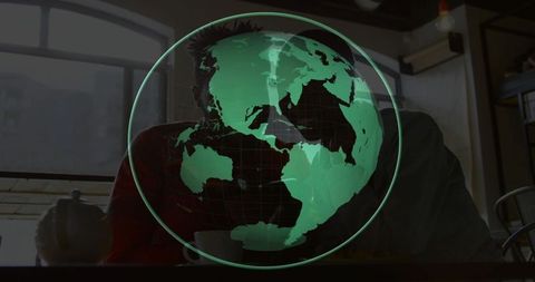 Couple viewing green holographic globe projection in dim industrial coffeehouse