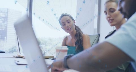 Team collaboration in modern office reviewing laptop screen