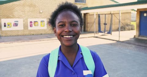 Smiling African Schoolgirl in Playground with Uniform and Backpack