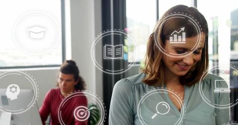 Smiling woman working in open-plan office surrounded by collaboration and digital icons