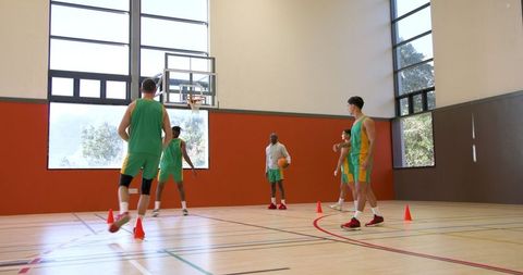 Diverse Male Basketball Team Training in Indoor Gym