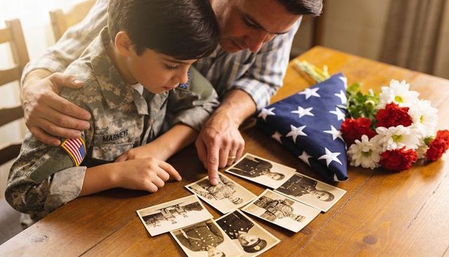 Father and son remembering military legacy while examining vintage service portraits