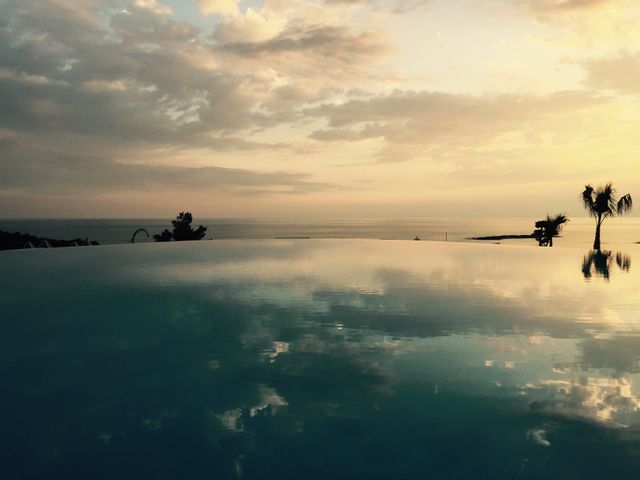 Serene Infinity Pool at Sunset with Reflective Sky and Ocean View - Download Free Stock Photos Pikwizard.com