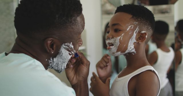 African american father is being shaved by his son in bathroom. staying at home in self isolation during quarantine lockdown.
