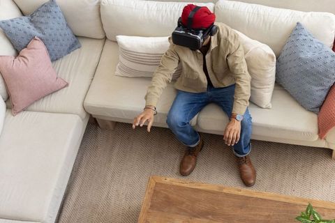 Man Experiencing Virtual Reality on Modern Living Room Sofa