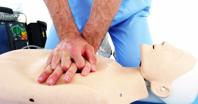 A healthcare professional is performing CPR on a training manikin, demonstrating emergency medical techniques. This scenario is typical for CPR certification courses where individuals learn life-saving procedures.
