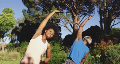 Energetic Couple Stretching Together in Sunlit Garden