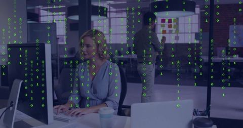 Businesswoman in Open Office Analyzing Data on Computer Screen