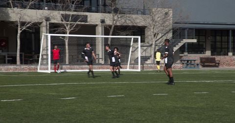 Youth soccer team players focus on goal during competitive match