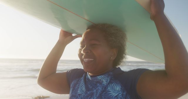 Smiling Senior Woman Carrying Surfboard on Beach at Sunset - Download Free Stock Images Pikwizard.com