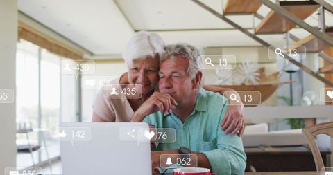 Senior Couple Embracing Technology With Laptop And Social Media Icons
