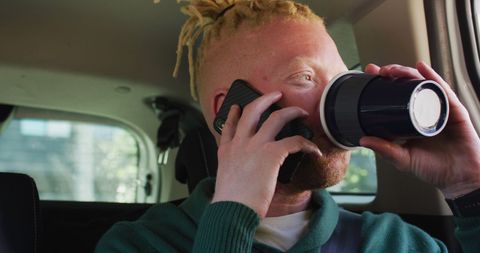 Busy Urban Professional with Blonde Dreadlocks Engaging in Multitasking in Car