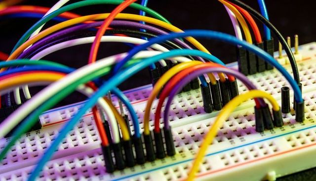 Colorful jumper wires arcing over solderless breadboard connecting electronic circuits