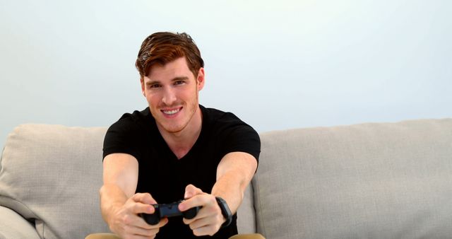 Young Man Playing Video Games Sitting on Couch with Game Controller - Download Free Stock Images Pikwizard.com