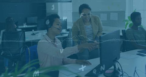 Diverse office team collaborating on project at computer