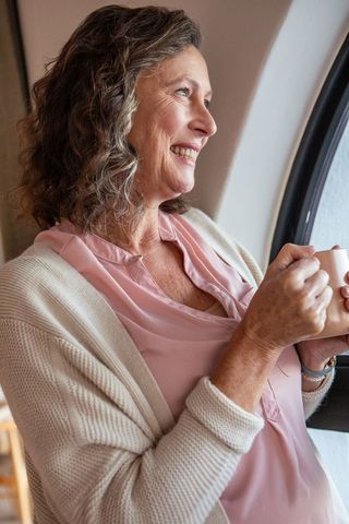 Senior Woman Enjoying Tea by Window Light