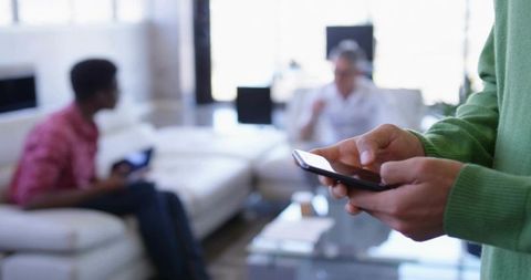 Businessman Using Smartphone in Modern Office Lounge Ahead of Meeting