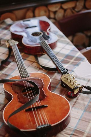 Vintage acoustic guitars resting on plaid tablecloth