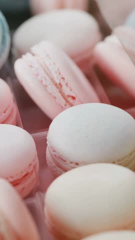 Vertical video shifting camera right bringing white macaron into focus in clear tray