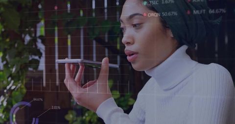 Young woman speaking to smartphone with analytics and data visualization overlay outdoors