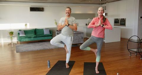 Senior Couple Practicing Yoga in Modern Open-Plan Living Area