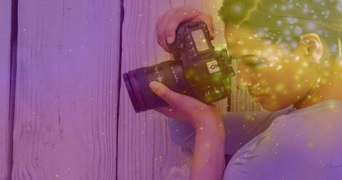 Photographer posing with dslr camera and magical particles