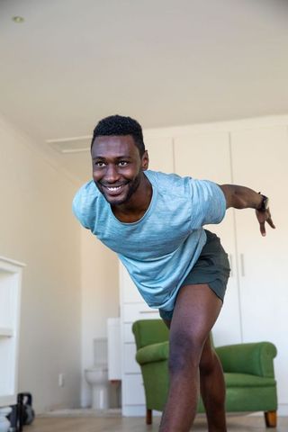 Young Man Practicing Balancing Exercise in Home Setting for Fitness Routine
