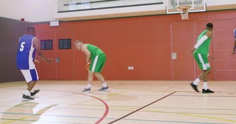 Defender intercepting dribbler in school basketball gym teamwork and competition