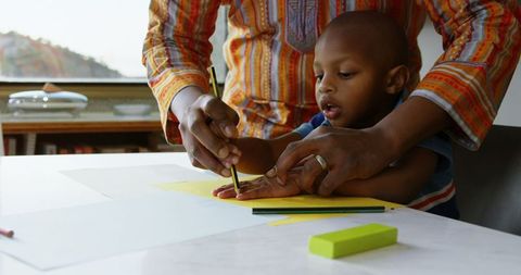 Father Teaching Young Son Drawing at Home
