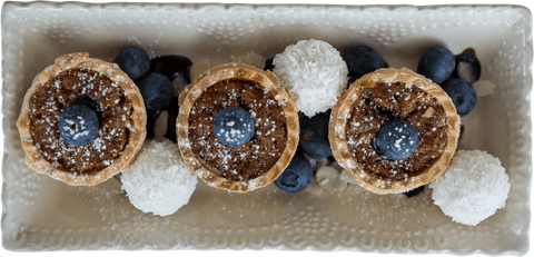 Elegant dessert arrangement on transparent tray with fresh berries