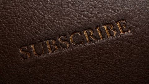 Embossed subscribe in gold foil on dark brown pebbled leather