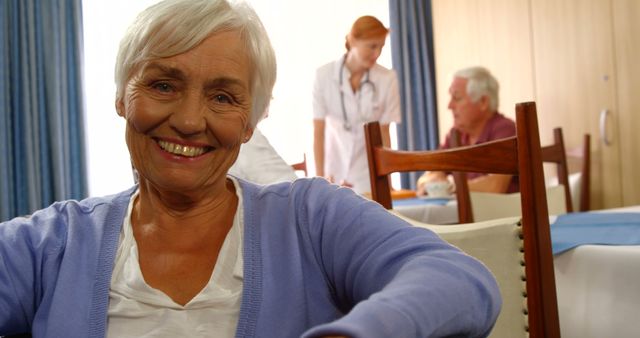Smiling Senior Woman Relaxing in Care Home Dining Area - Download Free Stock Images Pikwizard.com