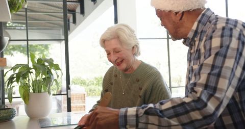 Senior Couple Joyfully Preparing Meal Together in Cozy Kitchen