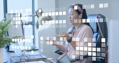 Asian woman leading virtual meeting at modern office desk