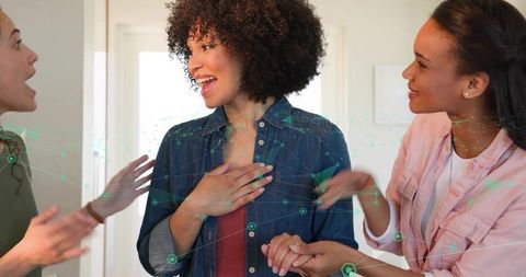 Friends celebrating and supporting woman receiving good news while smiling together
