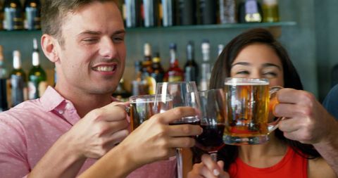 Friends Toasting Drinks at Lively Bar Setting Celebrating Together