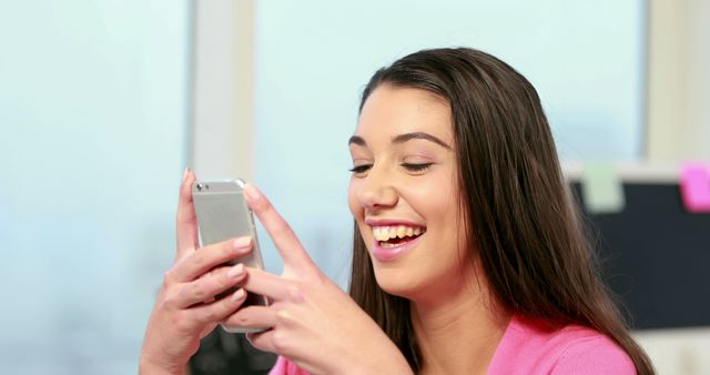 Smiling Woman Typing on Smartphone at Office Desk - Download Free Stock Images Pikwizard.com