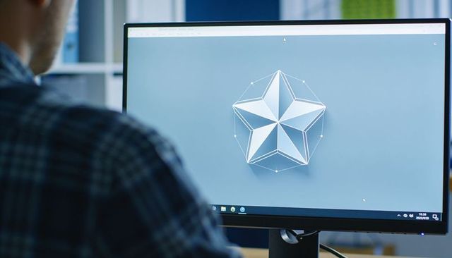 Designing 3d geometric star model on monitor with designer at workspace