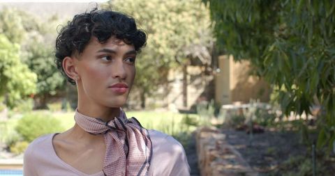 Elegant man in garden with stylish scarf in tranquil surroundings