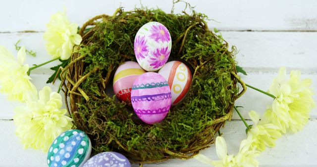 A nest filled with colorful decorated Easter eggs is surrounded by bright yellow flowers, with copy space. These vibrant eggs and fresh blooms symbolize the celebration of Easter and the arrival of spring.