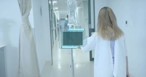 Patient Walking Down Hospital Corridor Pushing IV Drip Stand in Gown Medical Care