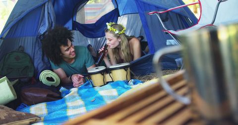 Young Couple Relaxing Inside Tent with Camping Gear