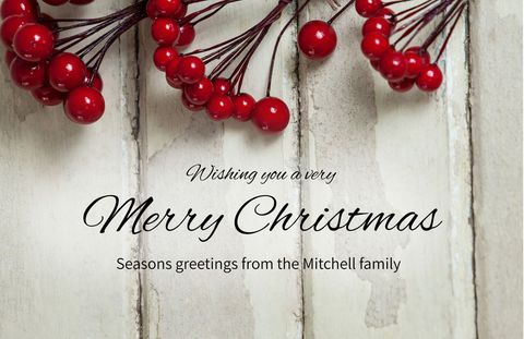 Festive christmas card with red berries on rustic wood background